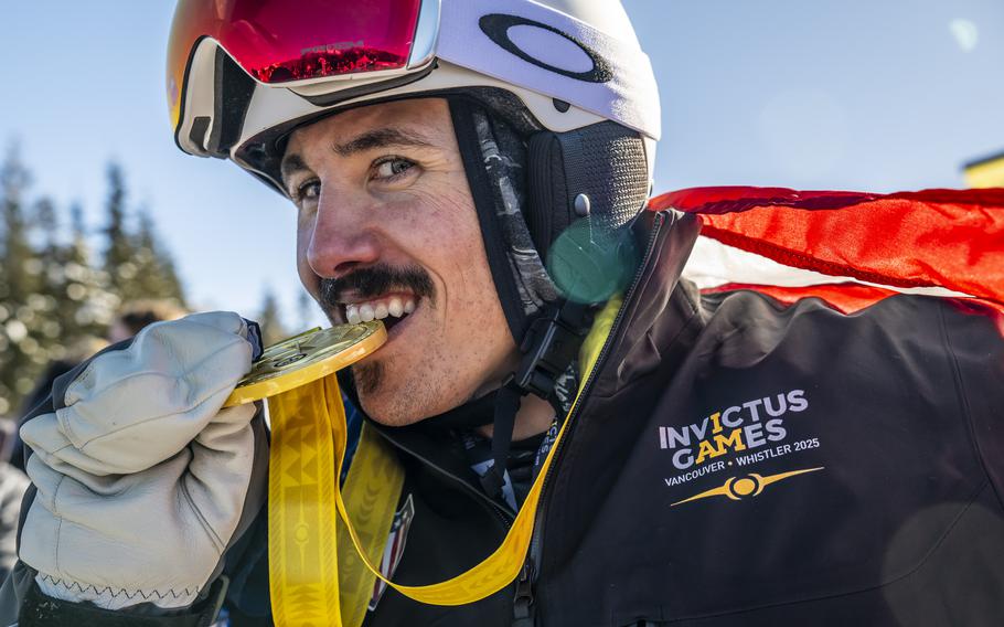 A competitor bites his gold medal