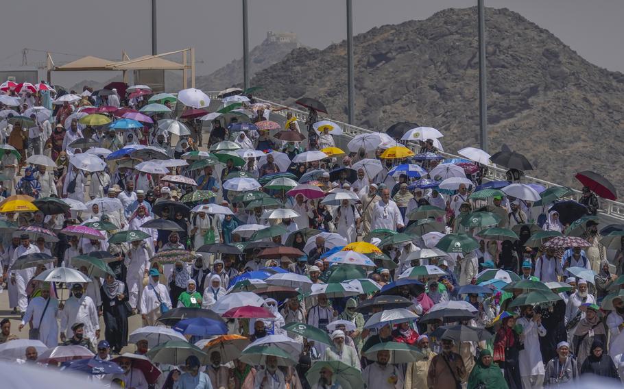Muslim pilgrims use umbrellas to shield themselves from the sun as they arrive to cast stones at pillars in the symbolic stoning of the devil, the last rite of the annual hajj, in Mina, near the holy city of Mecca, Saudi Arabia, Tuesday, June 18, 2024. 