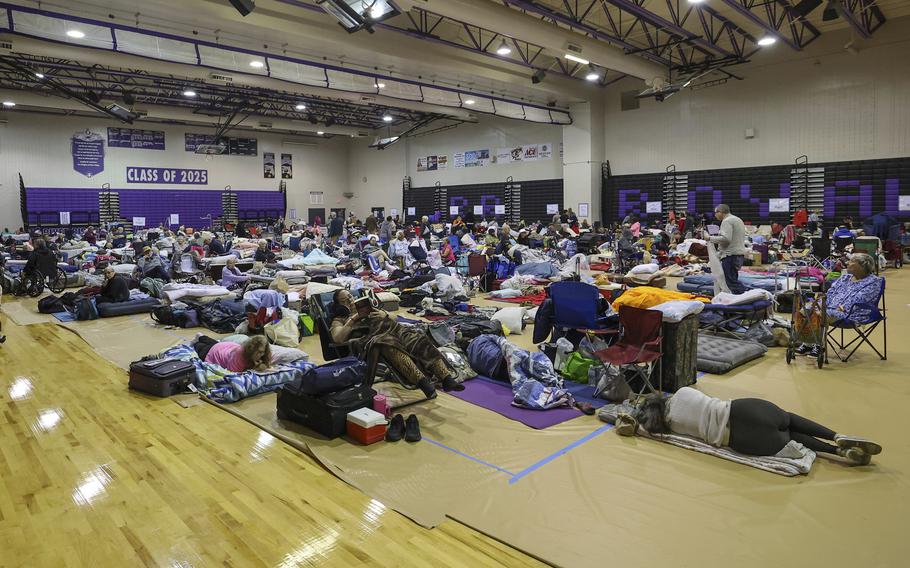 Hundreds of evacuees with sleeping bags and cots crowd into the gymnasium ahead of Hurricane Milton.