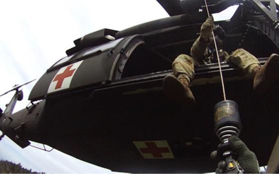 Tennessee Army National Guard Blackhawk helicopter crew chief, Sgt. Daniel Bandy, hoists flight paramedic, Sgt. 1st Class Giovanni DeZuani, into the aircraft after rescuing a hiker in respiratory distress in the Great Smoky Mountain National Park, May 31, 2024.  