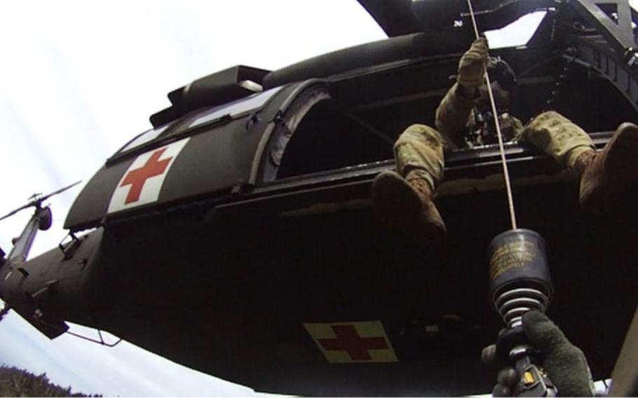 Tennessee Army National Guard Black Hawk helicopter crew chief Sgt. Daniel Bandy hoists flight paramedic Sgt. 1st Class Giovanni DeZuani after rescuing a hiker in respiratory distress in Great Smoky Mountain National Park on May 31, 2024.  