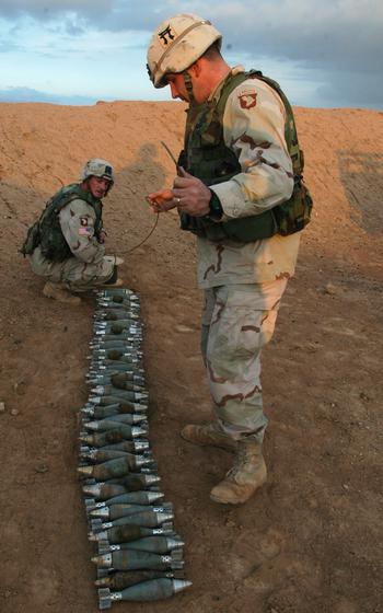 Sgt. Tim Jackowicz, 30, a combat engineer from Clarksville, Tenn., left; and Sgt. 1st Class Paul Dominguez, 39, a platoon sergeant from Hillside, N.J., prepare to wrap detonation cord around mortars and grenades near Sinjar, Iraq.