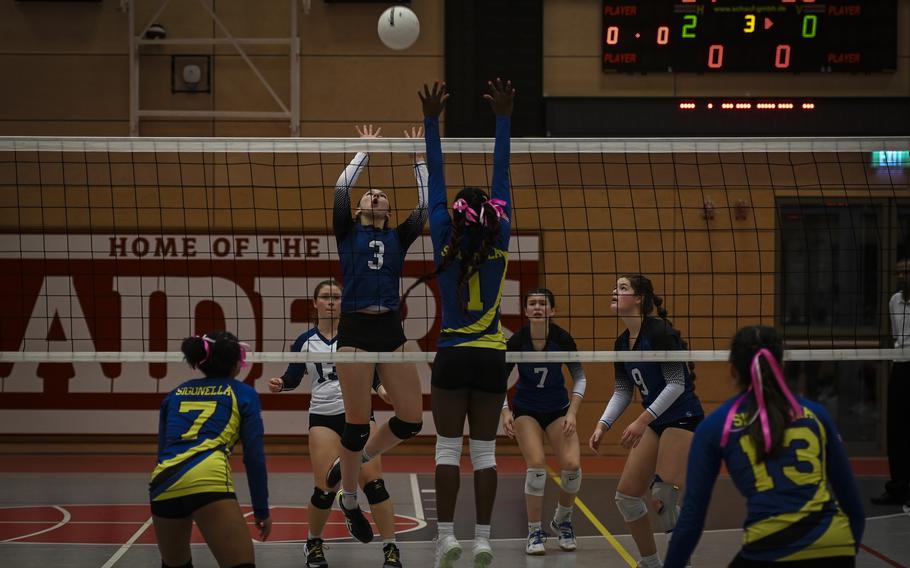 Brussels Brigand Lucia Martinez leaps to pitch the ball over, while Sigonella Jaguar Rickalia Goss rises in an attempt to block during the DODEA Division III European volleyball semifinals on Oct. 27, 2023, in Kaiserslautern, Germany.