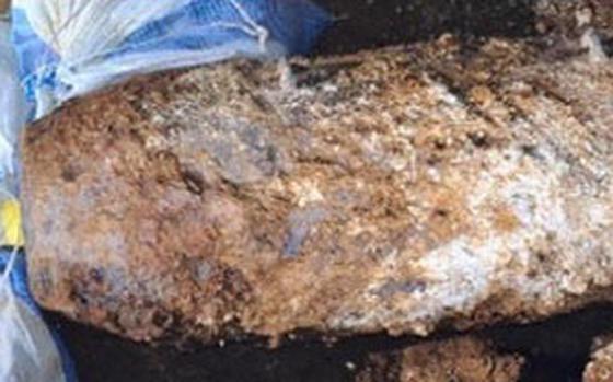 An unexploded World War II-era bomb crusted with dirt and debris.