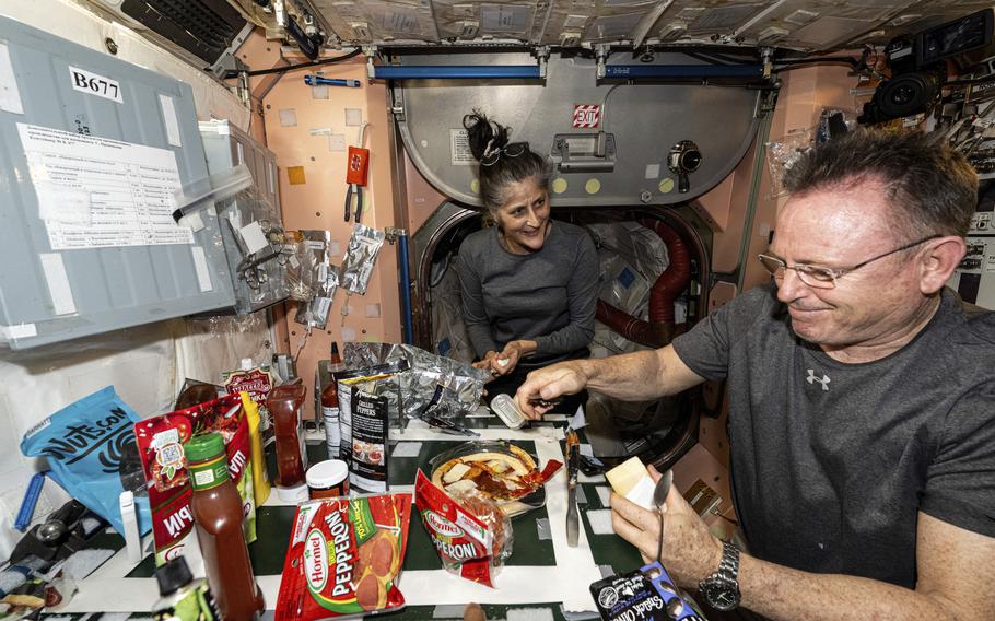 In this image released by NASA, NASA astronauts Suni Williams and Butch Wilmore, both Expedition 71 Flight Engineers, make pizza aboard the International Space Station’s galley.