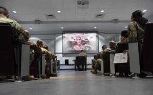 Airmen sit at desks during a seminar.