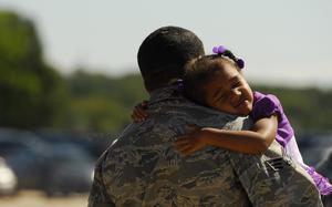 Kaliyah, three, hugs her father U.S. Air Force Senior Airman Damien Williams, 145th Aircraft Maintenance Squadron, during Family Day held at the North Carolina Air National Guard Base, Charlotte Douglas Interantional Airport, Oct. 4, 2014. The 145th Airlift Wing invited family members onto the base for a tour, commissary case lot sale, games, and tours of C-130 Hercules aircraft. (U.S. Air National Guard photo by Staff Sgt. Julianne M. Showalter, 145th Public Affairs/Released)