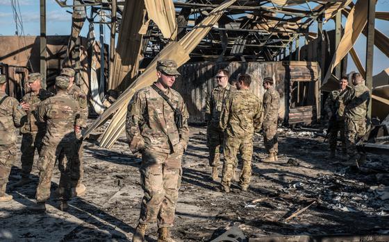 U.S. officials stand near a crater caused by Iranian airstrikes inside the Ain al-Asad base near Anbar, Iraq, on Jan. 13, 2020. MUST CREDIT: Emilienne Malfatto for The Washington Post