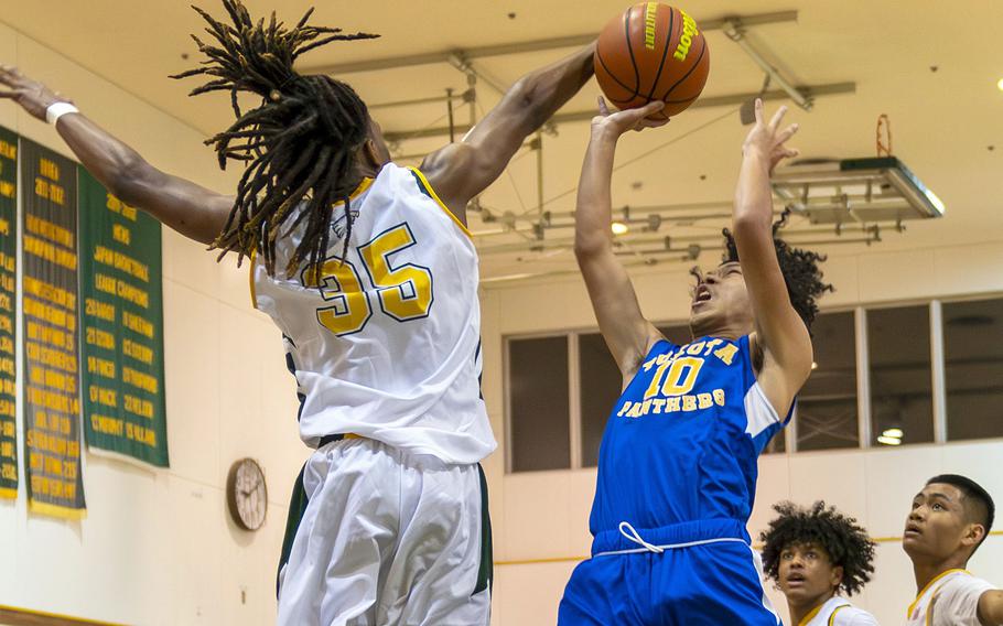 Robert D. Edgren's Je'Shawn Spaights-Pace blocks a shot by Yokota's Royce Canta during Friday's DODEA-Japan boys basketball game. The Panthers won 67-57.