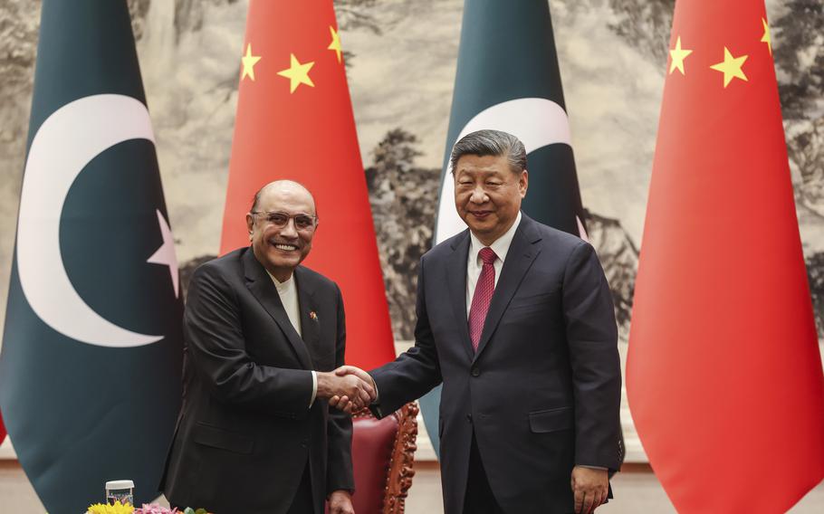 Chinese President Xi Jinping, right, shakes hands with Pakistani President Asif Ali Zardari 