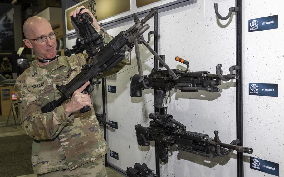 A solider looks over a rifle