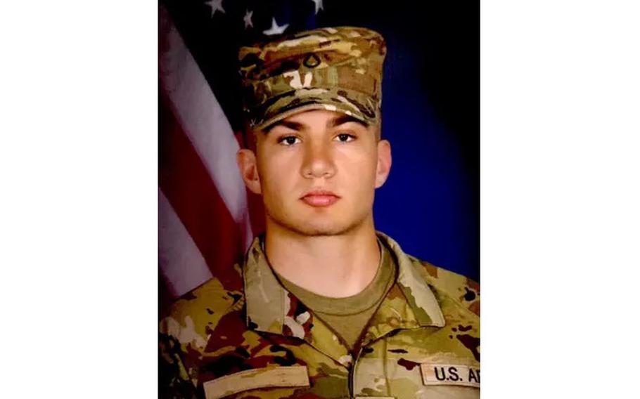 A portrait of a young man in an Army uniform against an American flag backdrop.