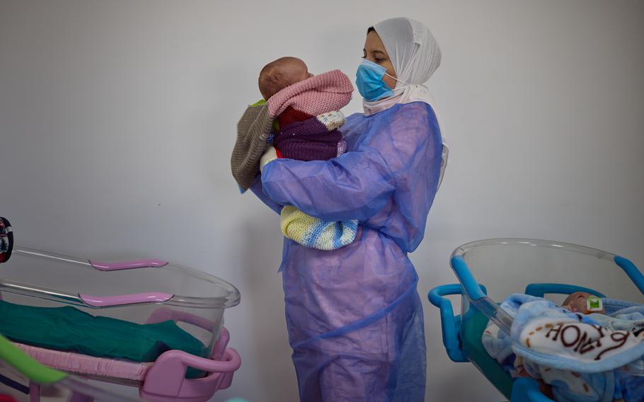 A nurse prepares Azhar for feeding at the hospital. Azhar’s father was able to travel to Egypt and reunite with her.