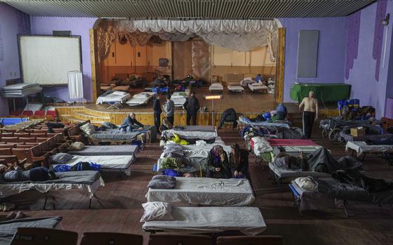 People sit on beds after evacuation from the frontline at a center for displaced people in Pavlohrad, Ukraine, Saturday, Feb. 1, 2024. (AP Photo/Evgeniy Maloletka)Maloletka)