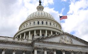 The American flag flies over the Capitol in April 2022. Some members of Congress are calling for the suspension of the so-called five-year rule, a measure that for many years has capped how long government service employees can work overseas in a military assignment.