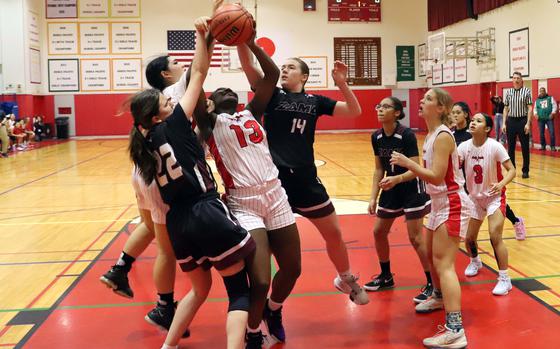 Kinnick's Danielle Hamilton goes for a rebound between Zama's Selah Falcon and Bella Hunter.