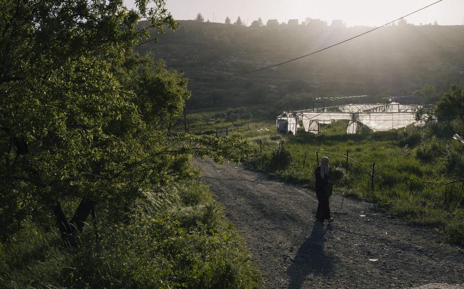 Farmer walks near destroyed greenhouse