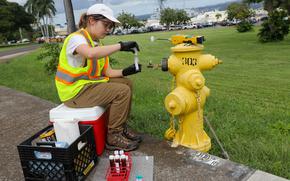 A Navy contractor collects water samples Jan. 31, 2024, as part of a long-term drinking water monitoring program at Joint Base Pearl Harbor-Hickam, Hawaii.