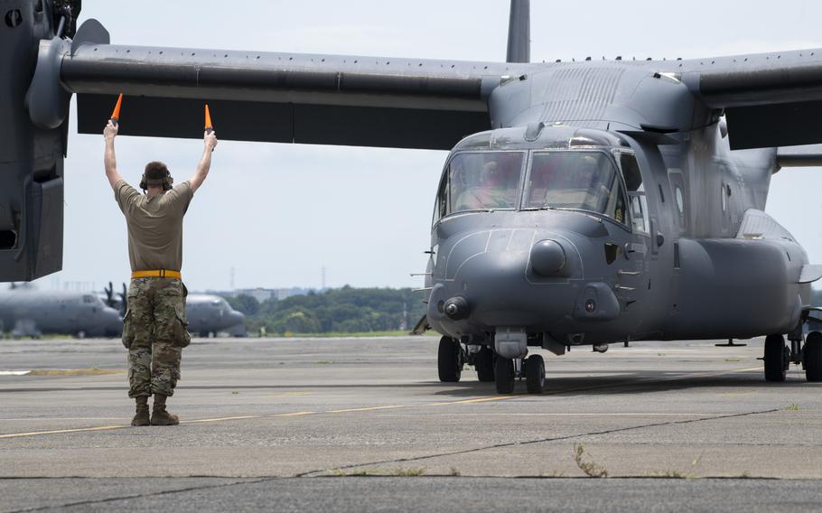 A crew chief marshals an Air Force CV-22B Osprey after returning from a flight at Yokota Air Base, Japan, July 2, 2024.