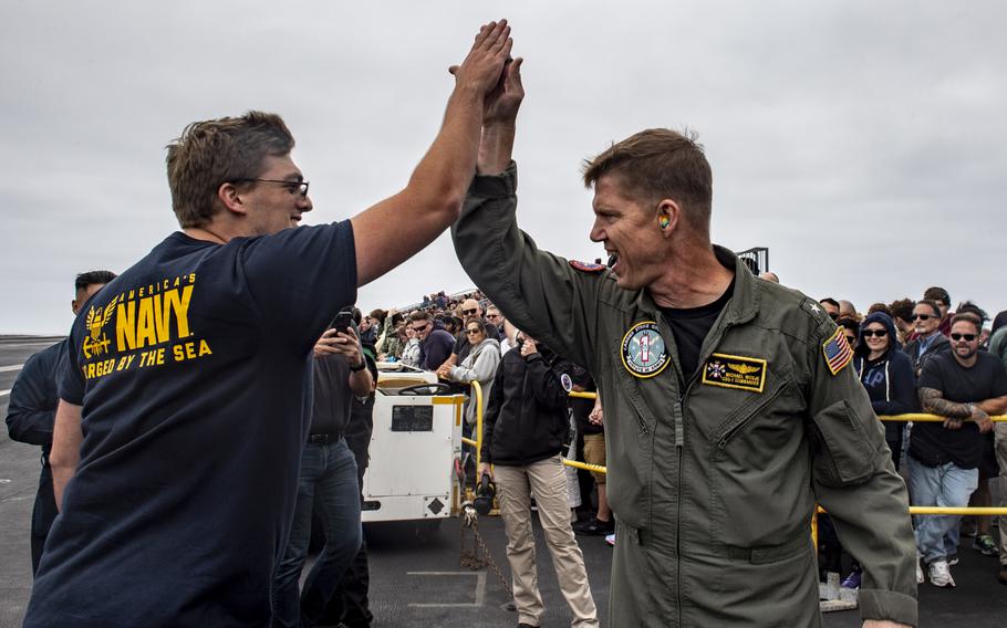 Rear Adm. Michael Wosje, commander of Carrier Strike Group One, high fives Trevor Sorenson of San Diego after Sorenson enlisted into the U.S. Navy aboard USS Carl Vinson while underway for a Family and Friends Day Cruise on Saturday, Aug. 17, 2024.