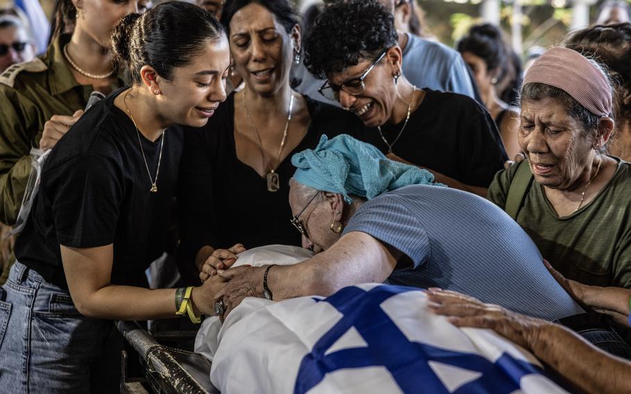 Family members are shown at a funeral for one of the Israeli hostages