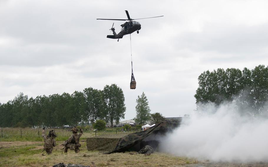 A helicopter brings in supplies during an air assault demonstration in Carentan, France, on June 2, 2024, marking the start of events in Normandy to commemorate the 80th anniversary of D-Day.