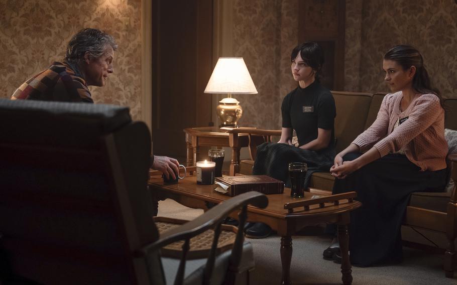 From left, Mr. Reed (Hugh Grant), Sister Barnes (Sophie Thatcher) and Sister Paxton (Chloe East) engage in a theological discussion in a scene from “Heretic.”