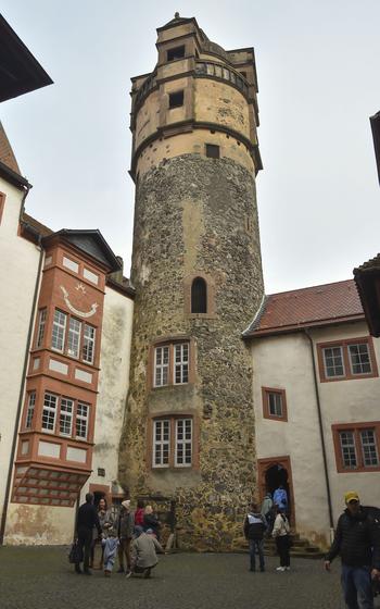 A tall stone tower stands at the corner of an inner castle courtyard.