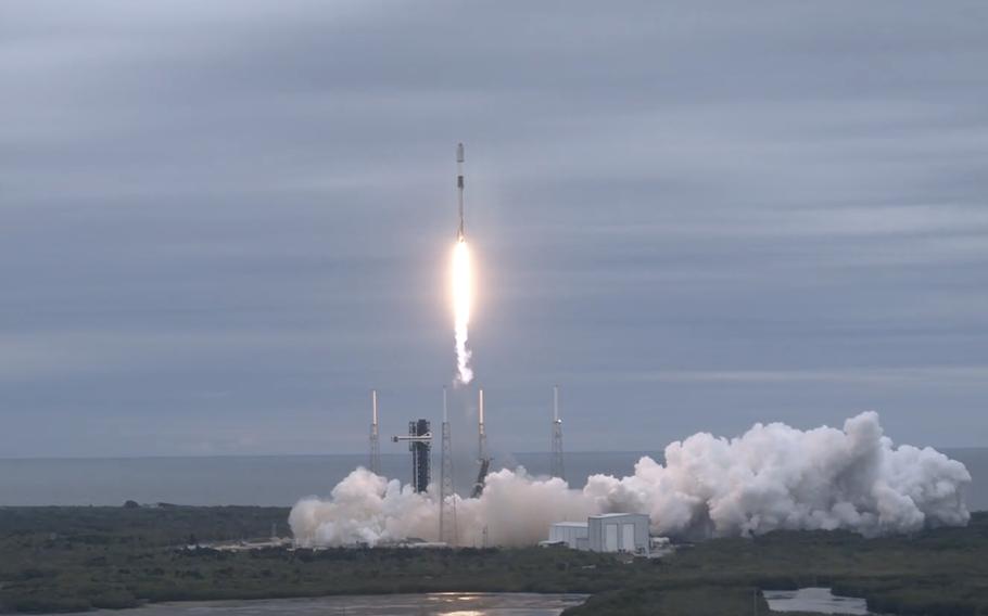 A rocket lifts off, with flames and smoke.