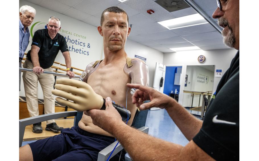 Ilia Mykhalchuk works with upper extremities specialist James Vandersea, right, while being fitted for prosthetics. 