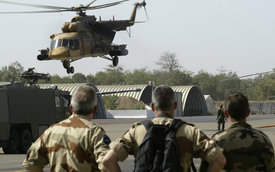 French troops watch a Chadian air force helicopter take off 