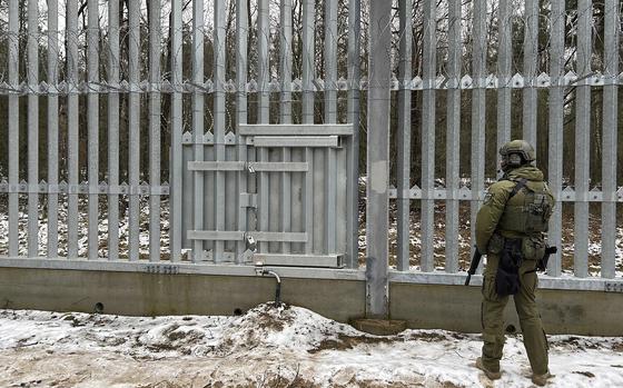 A Polish border guard looks east into Belarus at the crossing point Połowce-Pieszczatka in Polowce, Poland, Thursday, Jan. 16, 2025. (AP Photo/Lorne Cooke)