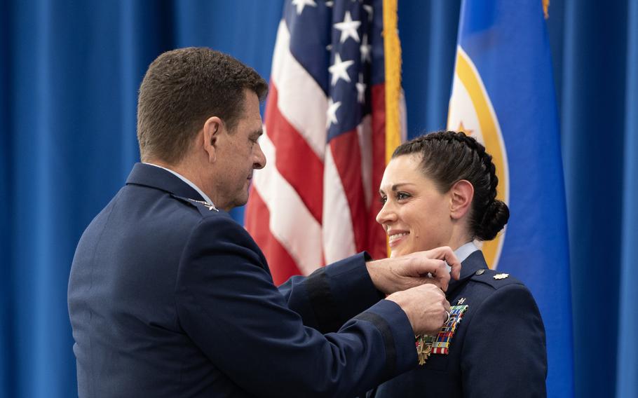 U.S. Air Force Lt. Gen. Michael A. Loh, Director of the Air National Guard, fastens the Distinguished Flying Cross onto Maj. Katie Lunning’s uniform St. Paul, Minn., Jan. 7, 2023. Loh’s visit was in honor of Lunning’s extraordinary actions during the evacuation of Kabul, Afghanistan on Aug. 26, 2021 which earned Lunning the Distinguished Flying Cross decoration.