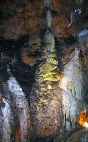 a colorful photo of a cave stalagmite formation that looks like a waterfall. 