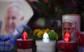 Candles and pictures of Pope Francis.