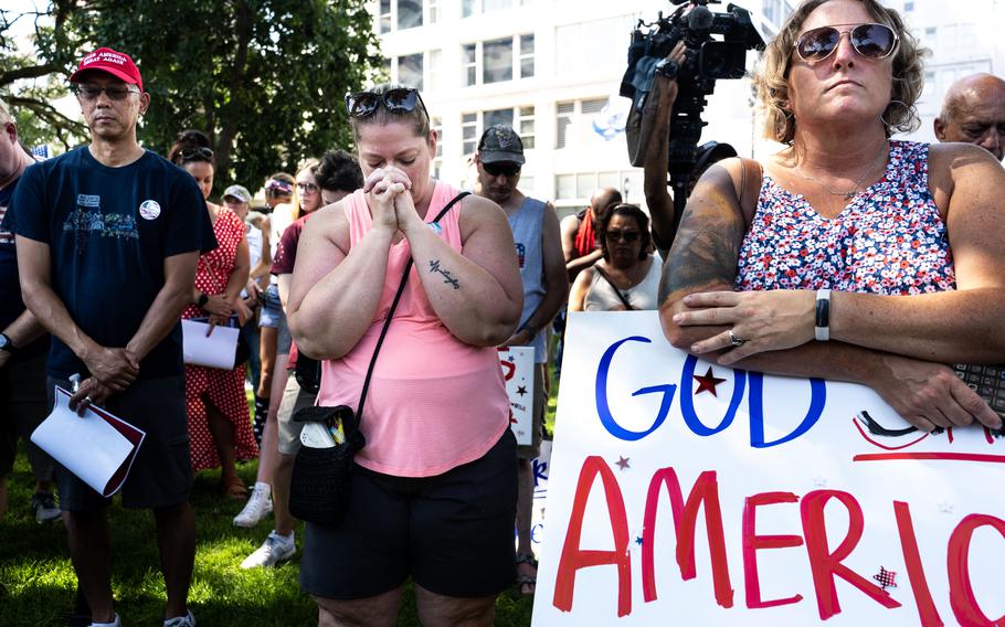 Cori Gasmen, center, and others hold a prayer vigil for Donald Trump at Zeidler Park in Milwaukee on Sunday, July 14, 2024.