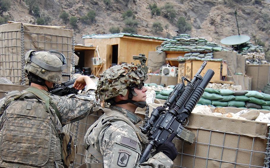 Troops of Chosen Company, 2nd Battalion, 503rd Infantry Regiment, 173rd Airborne Brigade in contact with the enemy prepare to return fire at Combat Outpost Bella, Afghanistan, in 2008. Harassment attacks on COP Bella followed the publicized announcement of Bella's closure, prior to the unit's move to Wanat.
