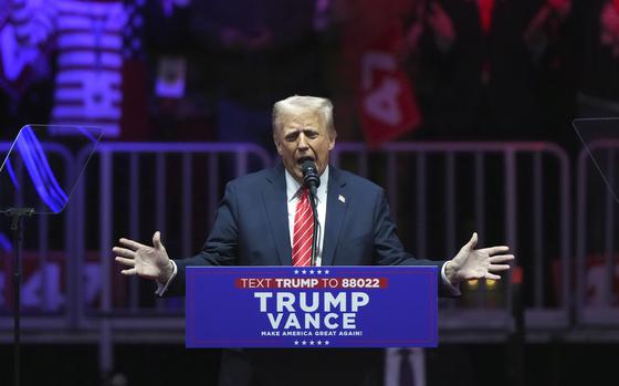 Donald Trump stands speaks into a microphone at a podium.