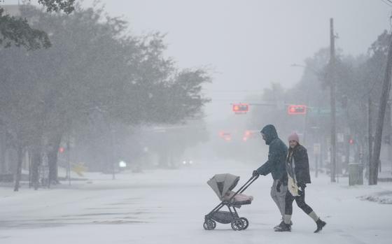 People take a walk in the neighborhood Tuesday, Jan. 21, 2025, in Houston. (AP Photo/Ashley Landis)