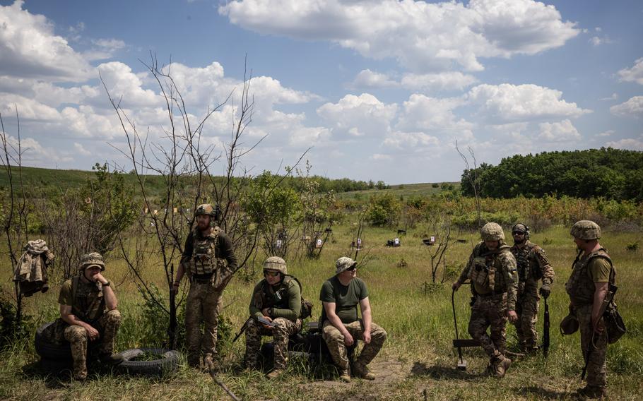 Soldiers from Ukraine’s 41st Brigade wait to learn trench warfare and other drills in May in the Donetsk region. A newly adopted mobilization law is intended to widen the pool of draft-eligible men to replenish Ukraine’s ranks as Russia presses an offensive. 