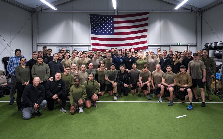 Secretary of Defense Pete Hegseth poses for a photo after a morning PT session hosted by troops