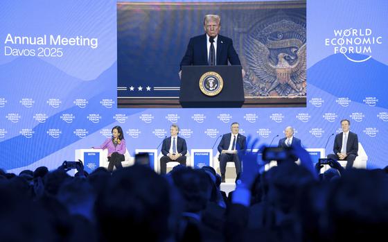 US President Donald J. Trump is shown on screens as he addresses via remote connection a plenary session in the Congress Hall, during the 55th annual meeting of the World Economic Forum (WEF), in Davos, Switzerland, Thursday, Jan. 23, 2025. (Michael Buholzer/Keystone via AP)