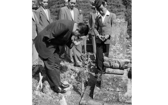 Yokoyama, Japan, Oct. 2, 1960: Rep. Daniel K. Inouye (D-Hawaii) bows in prayer at his great-grandfather's grave in his ancestral village of Yokoyama, Japan.Congressman Inouye came to Japan Oct. 2, 1960 to visit visited the mountain village of Yokoyama – the birthplace of his father and where some of his uncles and cousins still live. The Hawaiian congressman met many of the 2,200 villagers of Yokoyama – some 400 of whom are named Inouye. During his 3½-hour tour, he visited his ancestral cemetery and had lunch with his relatives.  He discovered the tombstone bearing the family crest when visiting the cemetery. 

Read the article and see additional photographs of the late Sen. Daniel K. Inouye's visit to his paternal home here. 

META TAGS: Asian Pacific Heritage Month; U.S. Congress; politician; visit; ancestry; Yame-gun; Congressional history;