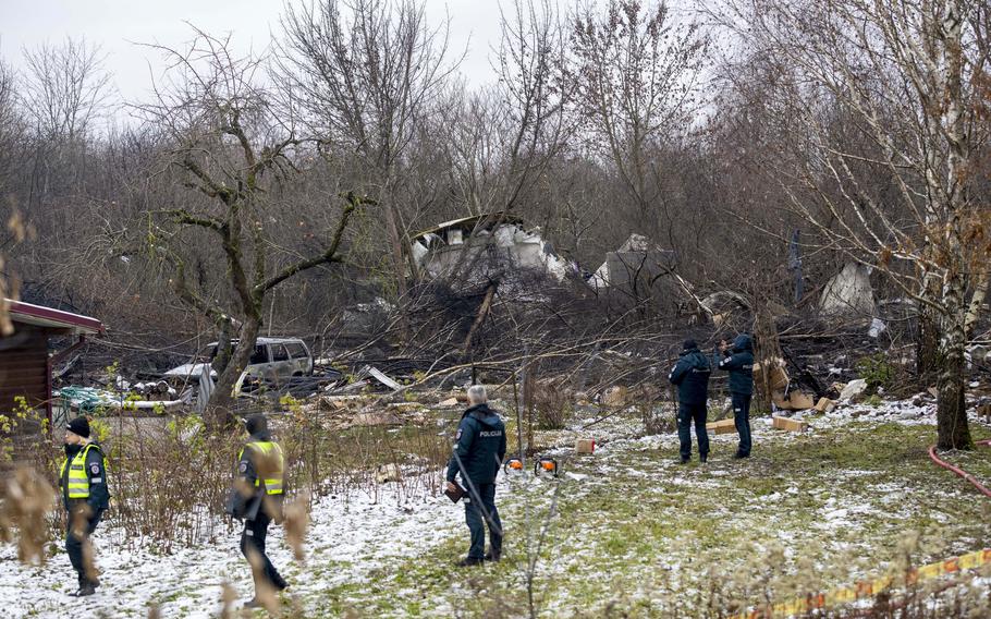 Emergency workers survey a destroyed cargo plane resting among the trees in the Vilnius area of Lithuania, Nov. 25, 2024.