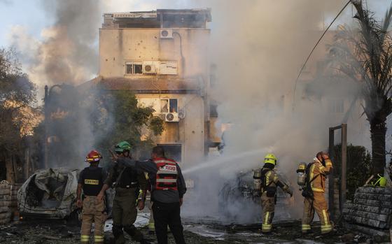 Israeli security and rescue forces work at the site hit by a rocket fired from Lebanon, in Kiryat Bialik, northern Israel, on Sunday, Sept. 22, 2024. (AP Photo/Gil Nechushtan)