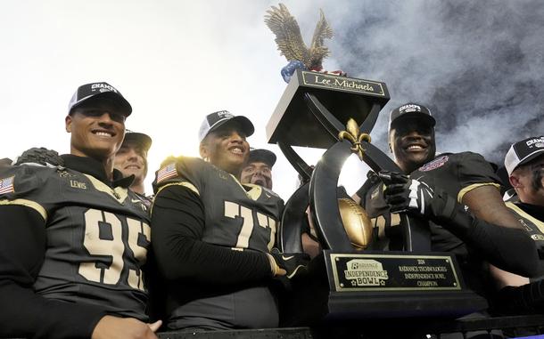 Army players hoist the winner's trophy following their win over Louisiana Tech during a NCAA college football game, Saturday, Dec. 28, 2024, in Shreveport, La. (AP Photo/Rogelio V. Solis)