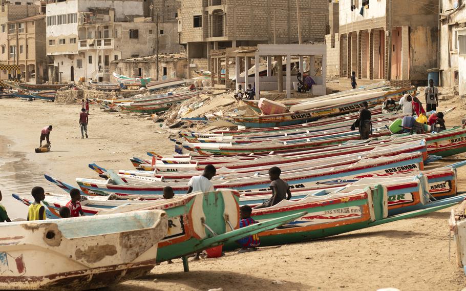 Children play on fishing boats known as “pirogues” in Dakar, Senegal, June 24, 2023. Large pirogues are used in migrant crossings from Senegal to Spain.