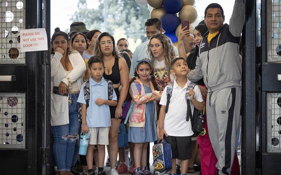 A child weeps with her parent before joining her classmates on the first day of school for the Anaheim Elementary School District at Roosevelt Elementary in Anaheim, Calif., Aug. 10. 