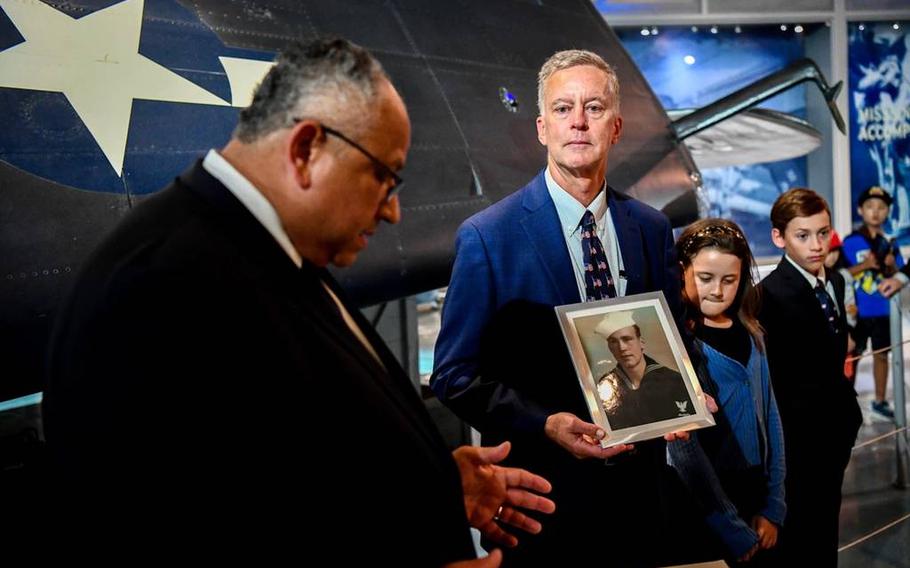 James Smith holds a photo of his father, Navy Petty Officer 3rd Class Peter L. Smith, on Aug. 16, 2023, at the Intrepid Sea, Air & Space Museum in New York City, where Navy Secretary Carlos Del Toro honored Peter Smith’s service in World War II. 