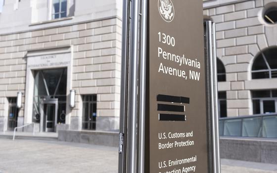 A sign showing a list of agencies housed at a nearby building complex, with one occupant’s name taped over.